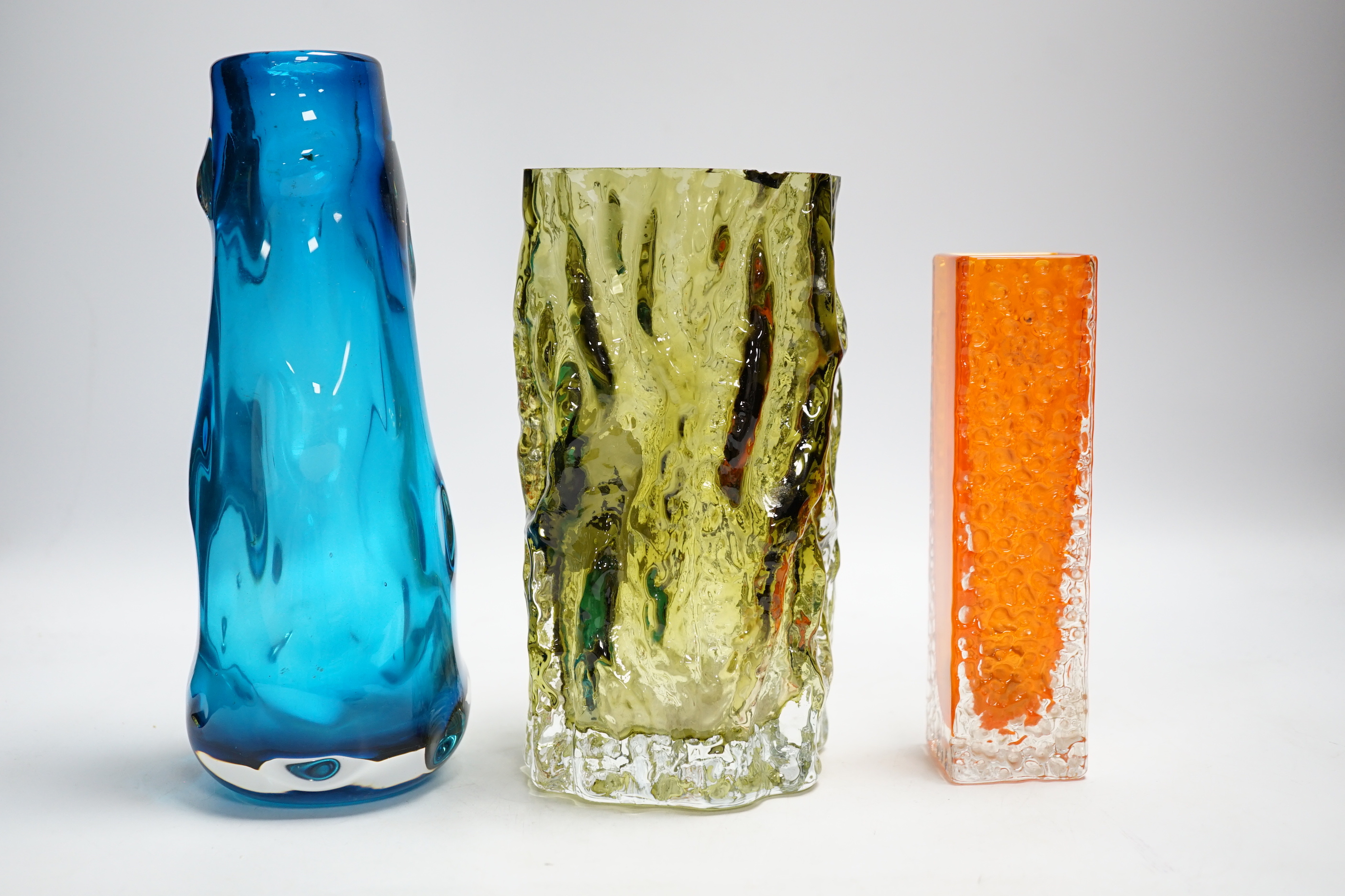 Three Whitefriars glass vases - a ‘Knobbly’ vase in kingfisher blue, a ‘Nailhead’ vase in tangerine and a ‘Bark’ vase in sage (cut down)